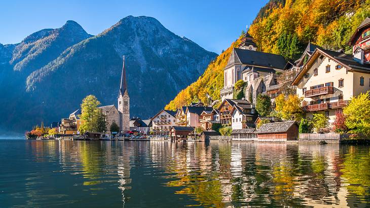 Old wooden houses and a tall clocktower against a mountain, overlooking the water