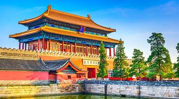 A large imperial palace building with Chinese architecture under a clear blue sky