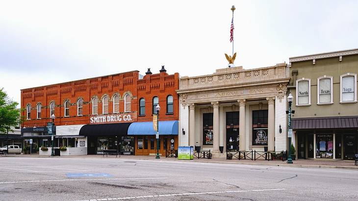 Old-fashioned shops in orange brick buildings and a stone building with columns