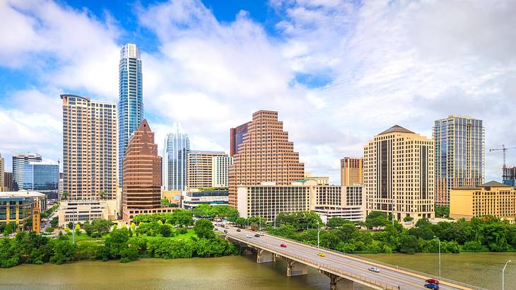 A city skyline with a river in front and a bridge over the river leading to the city A city skyline with a river in front and a bridge over the river leading to the city