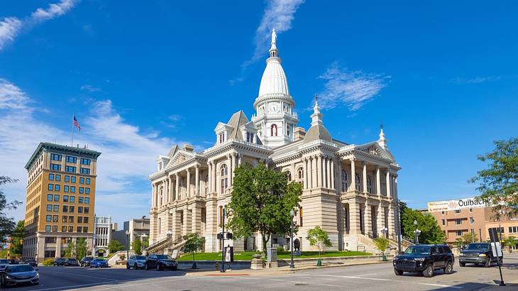 A stone courthouse building with a domed roof under a clear blue sky