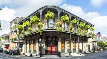 Historic two storey building arches along the balcony and colorful plants hanging Historic two storey building arches along the balcony and colorful plants hanging