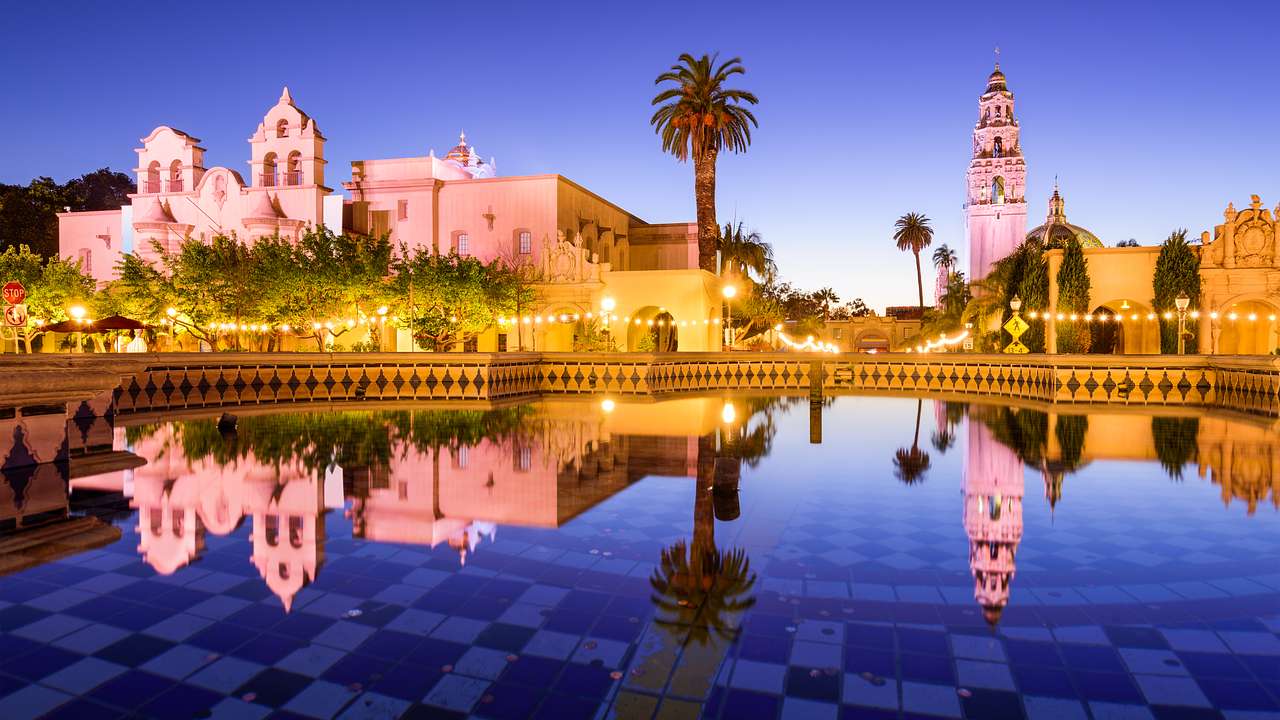 Spanish Colonial Revival-style buildings reflected in a pool at night