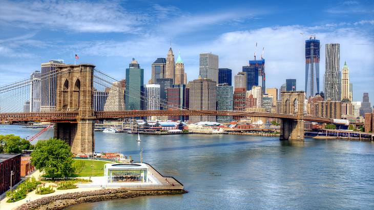 The Manhattan skyline with skyscrapers, Brooklyn Bridge, and water in front