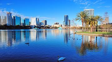 A body of water with a city in the background and clear blue sky A body of water with a city in the background and clear blue sky