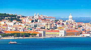 A view of a coastal city with white buildings with orange roofs next to the water A view of a coastal city with white buildings with orange roofs next to the water