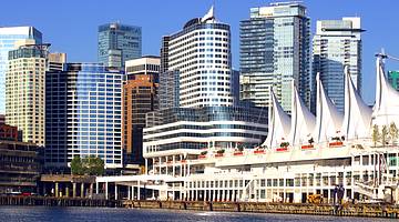A harbor in front of skyscrapers under a sunny blue sky