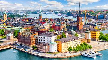 A Swedish city with colourful buildings surrounded by water on a bright day