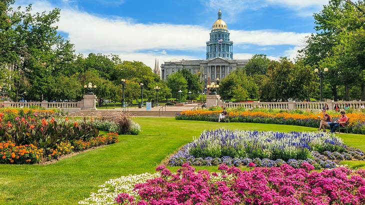 Colorado State Capitol Building in Denver, behind rows of bright-colored flowers