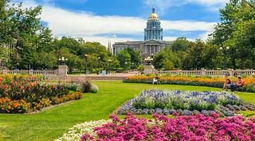 Colorado State Capitol Building in Denver, behind rows of bright-colored flowers Colorado State Capitol Building in Denver, behind rows of bright-colored flowers