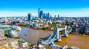 London skyline with tall buildings and a river with a bridge over it in England, UK