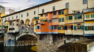 Colorful buildings on a stone arched bridge over a canal