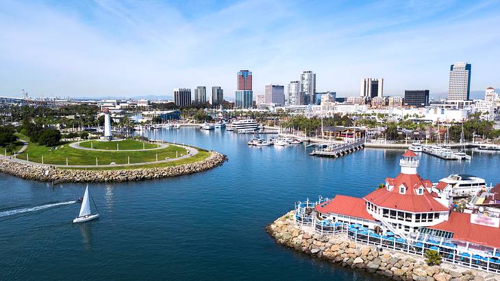 A calm body of water surrounded by boats and buildings under partially cloudy skies