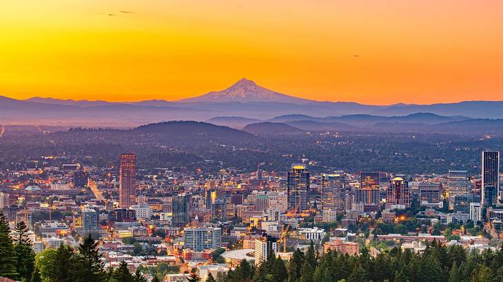 Aerial of an illuminated skyline against a hazy mountain peak under a yellow sky Aerial of an illuminated skyline against a hazy mountain peak under a yellow sky