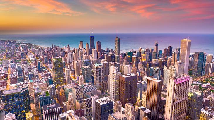 Aerial of the Chicago skyline with water, skyscrapers, and a sunset sky