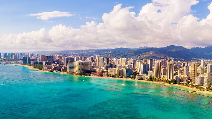 Clouds looming above a coastal city with buildings along the beach Clouds looming above a coastal city with buildings along the beach