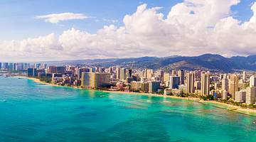 Clouds looming above a coastal city with buildings along the beach