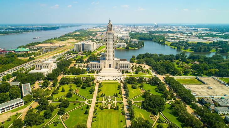 A view over a city park with a tall tower next to a river