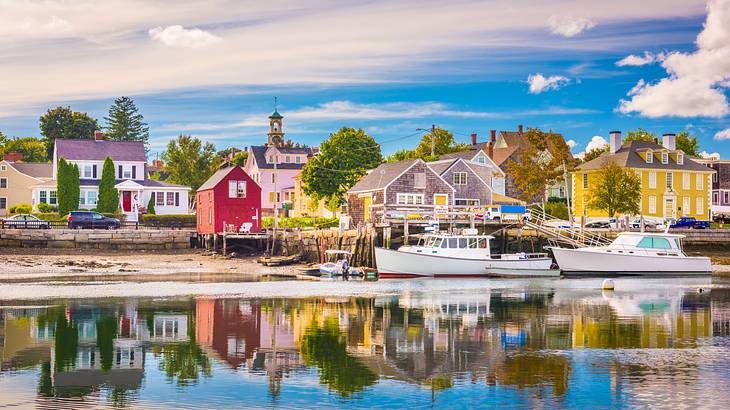 A picturesque waterfront with colorful buildings and two boats on the right