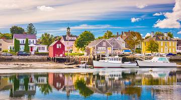 A picturesque waterfront with colorful buildings and two boats on the right