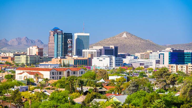 A city skyline with a clear blue sky and a mountain in the background