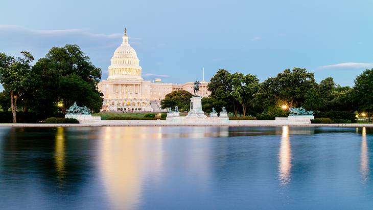 The US Capitol Building with a lake in front of it and trees to the side