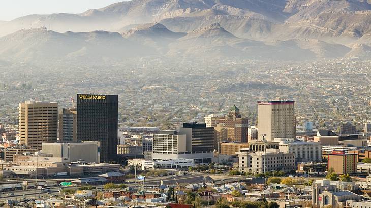 A city skyline with mountain ranges in the background