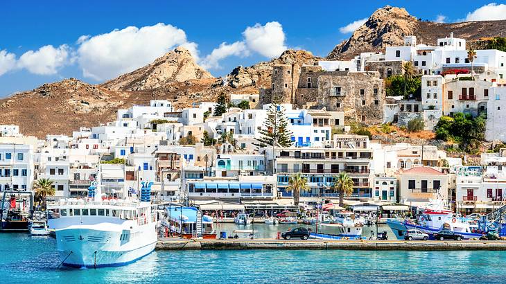 A coastal village with many white houses near mountains and boats