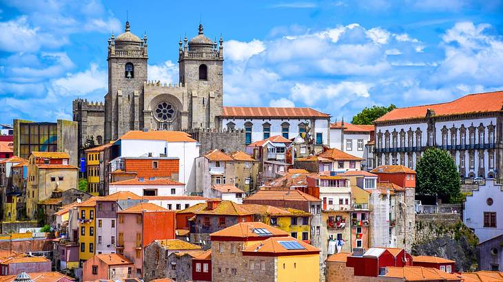 An aerial shot of a town with colorful houses near an old cathedral