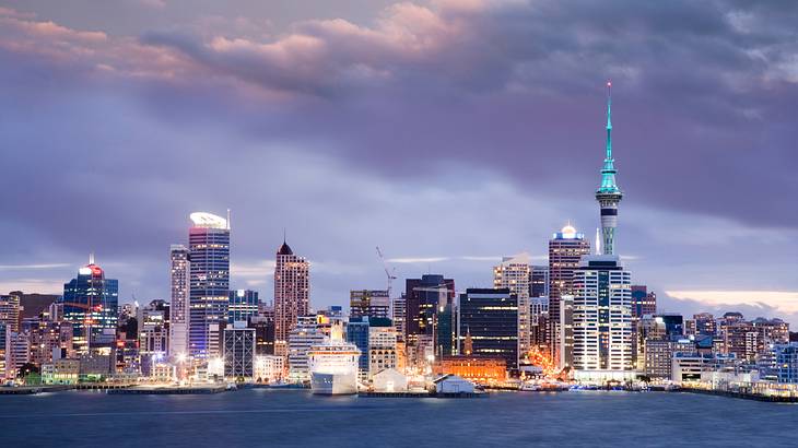 Dramatic sky and skyline of Auckland with many buildings at twilight, New Zealand
