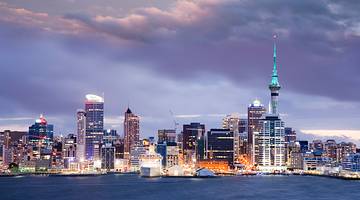 Dramatic sky and skyline of Auckland with many buildings at twilight, New Zealand