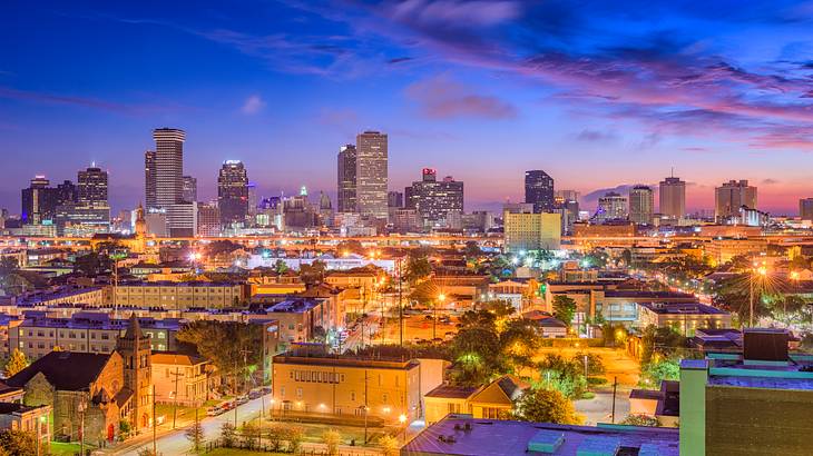 A view of New Orleans at night with illuminated buildings and skyscrapers