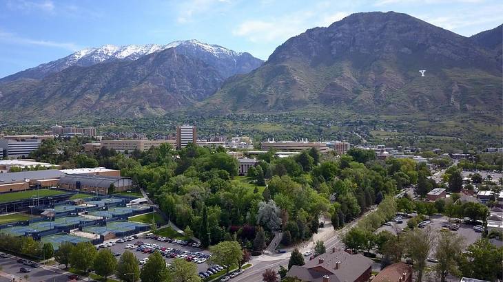 Greenery-covered mountains with trees and a town in front of them