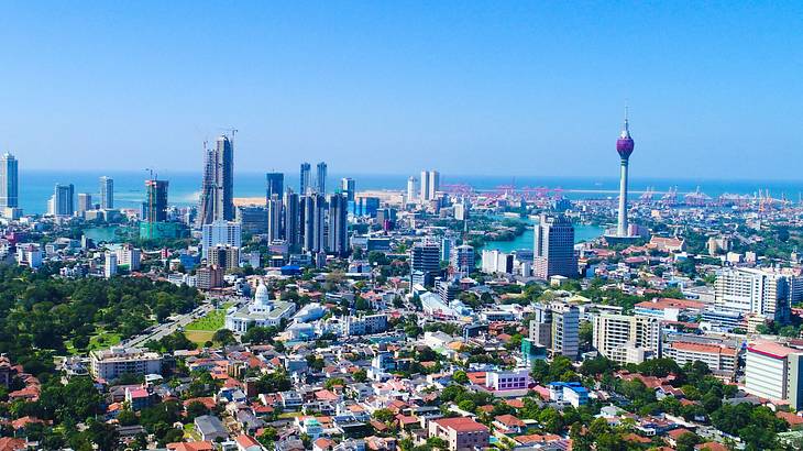 Aerial view of a city skyline, buildings, and a body of water at a distance