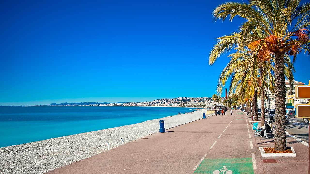 A promenade by a calm blue sea with clear skies