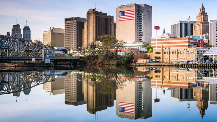 City buildings and a bridge with its reflection on a nearby body of water