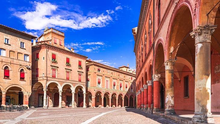 An empty, paved open area surrounded by red-pink colored buildings