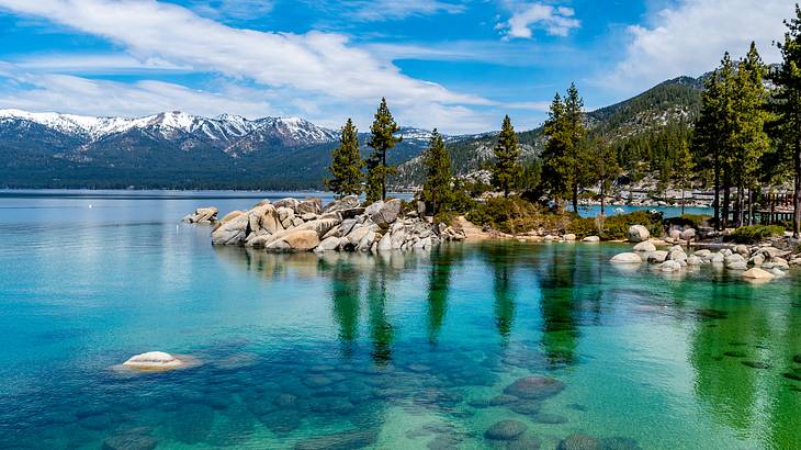 A lake with clear waters near rocks and trees