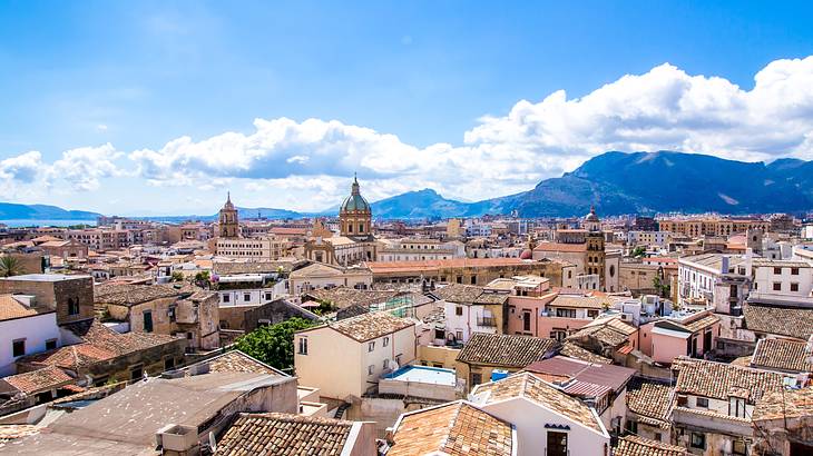 Aerial shot of a city with old towers and buildings with tiled roofs