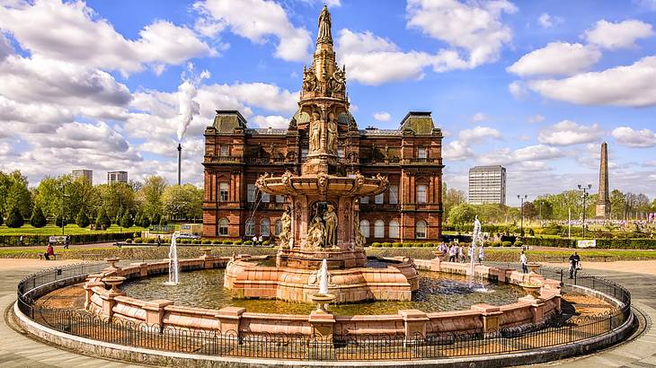 An intricately-designed old palace with people walking near a large fountain in front