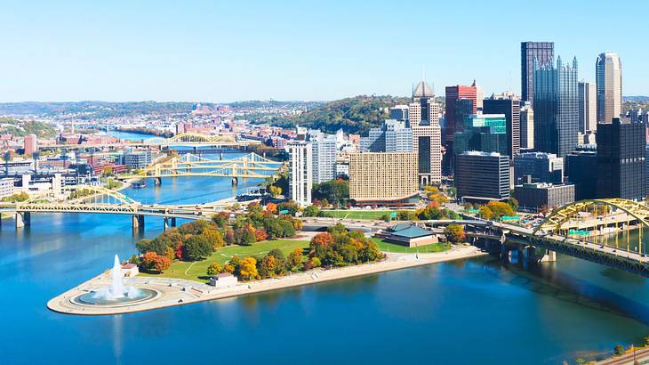 Buildings and skyscrapers by a river with bridges over it