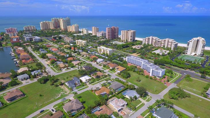 Aerial shot of an urban residential area with the ocean in the background