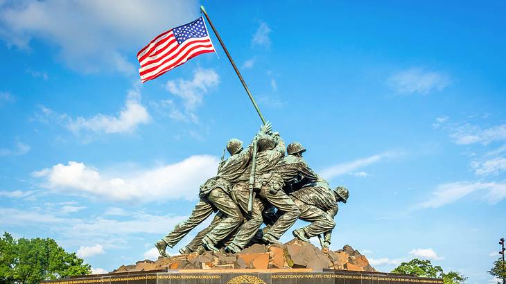 Bronze statue of soldiers carrying an American flag