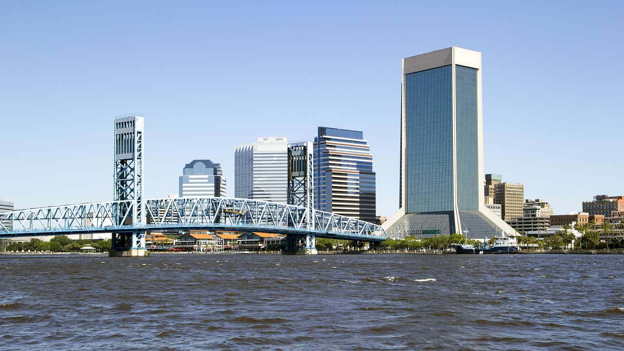 A bridge and skyscrapers next to a body of water