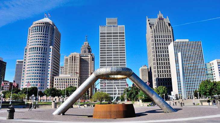 An art installation in an open area near skyscrapers in the background