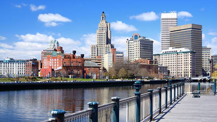 City skyline with a river and a boardwalk in the foreground