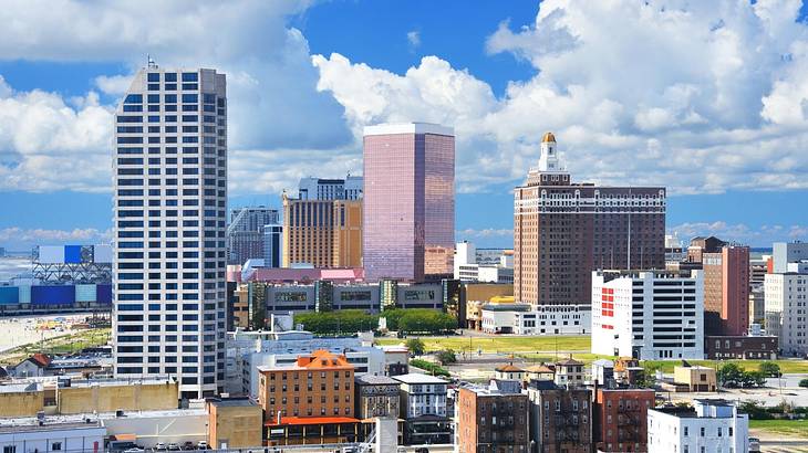 A city with skyscrapers and other buildings under a blue sky with clouds