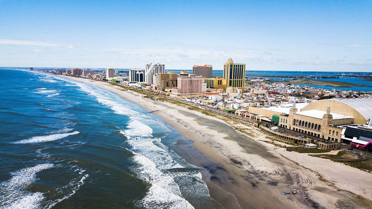 Aerial view of a coastal city with buildings along a sandy beach