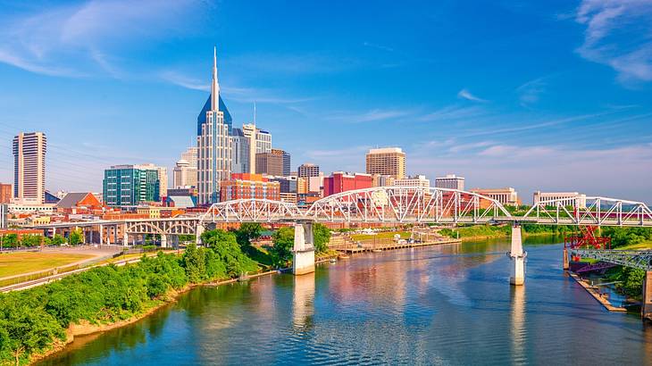 A bridge and river with famous landmarks in Nashville, Tennessee, behind