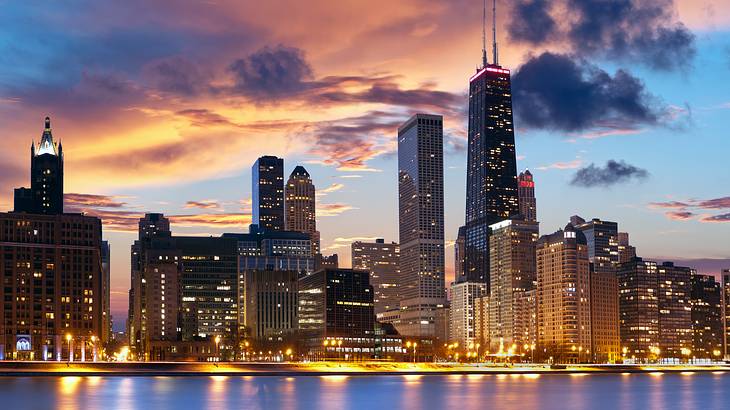 The Chicago city skyline at night with water in front of it